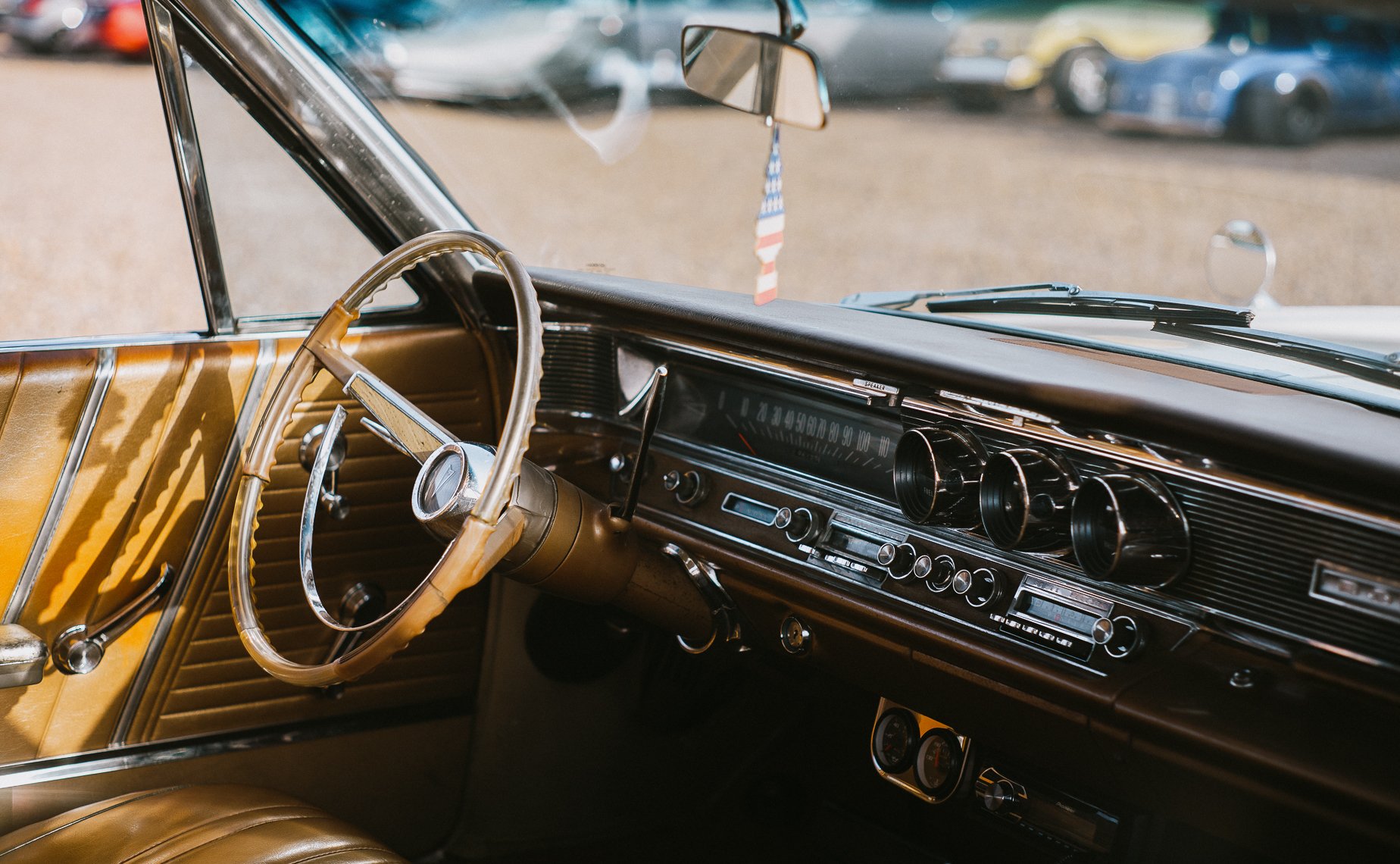 The interior dashboard of of a classic car at sunset